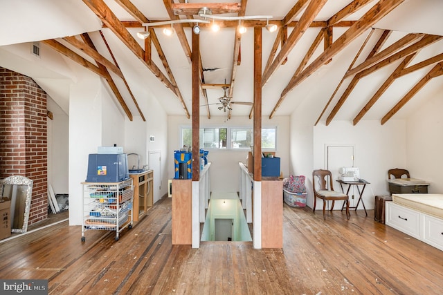 interior space with lofted ceiling with beams and hardwood / wood-style floors