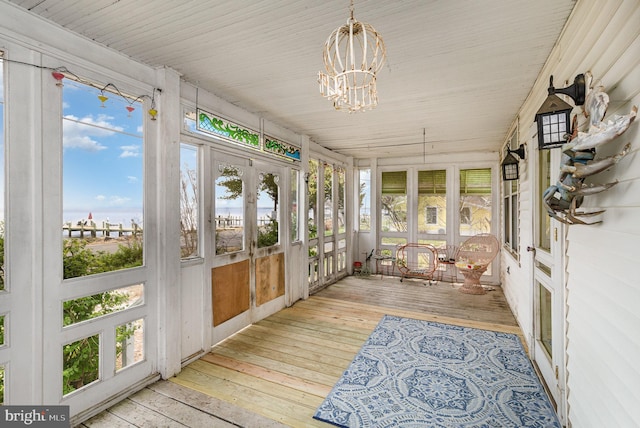 unfurnished sunroom featuring a notable chandelier