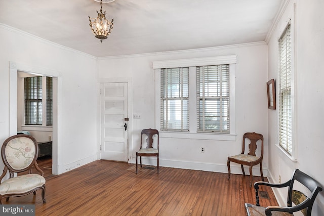 entrance foyer with baseboards, crown molding, wood finished floors, and a chandelier