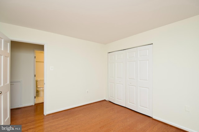 unfurnished bedroom featuring a closet, baseboards, and light wood-style floors