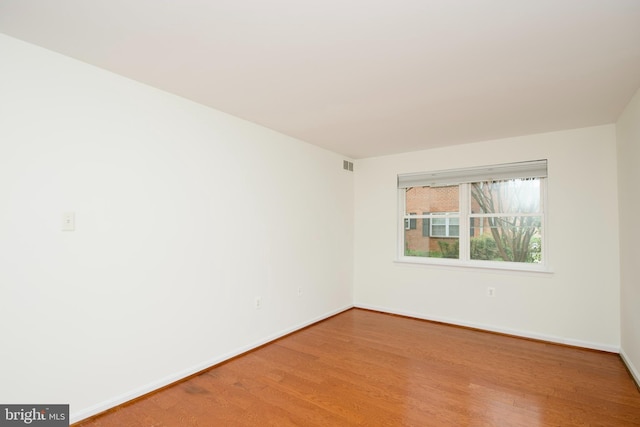 unfurnished room featuring visible vents, light wood-style flooring, and baseboards