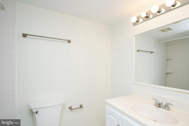 bathroom with a shower, vanity, visible vents, and toilet