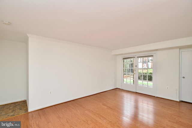 unfurnished room with baseboards, crown molding, and wood finished floors