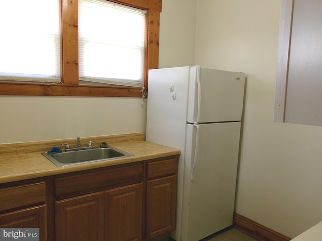 4204 Kenwood Ave, Baltimore, MD 21206 - kitchen with light countertops, a sink, and freestanding refrigerator