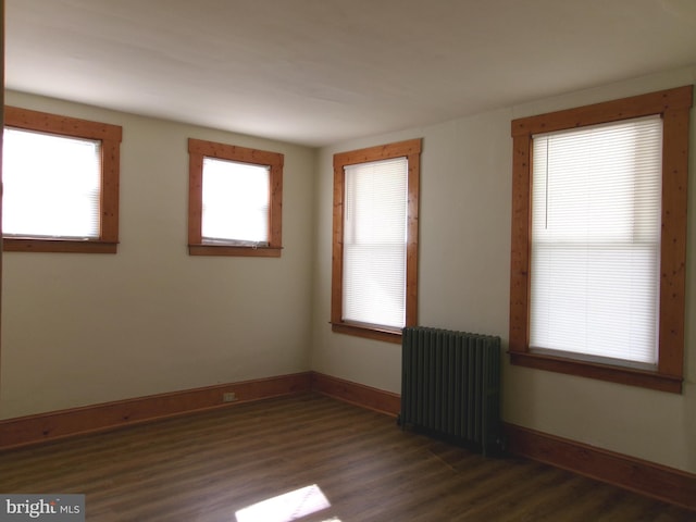 4204 Kenwood Ave, Baltimore, MD 21206 - unfurnished room featuring radiator heating unit, dark wood-type flooring, and baseboards