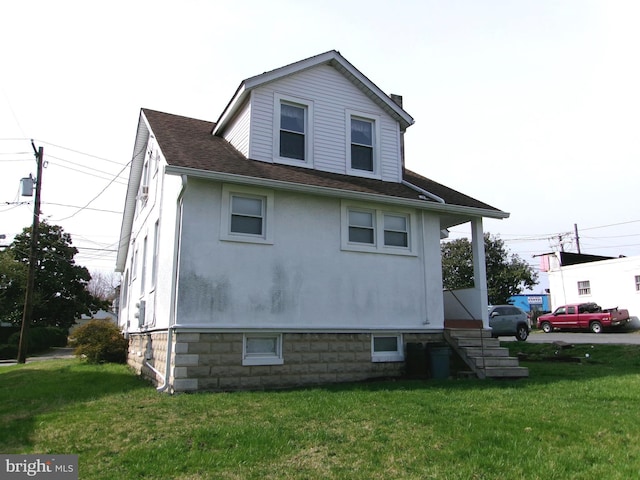4204 Kenwood Ave, Baltimore, MD 21206 - view of side of home with stucco siding, a shingled roof, and a yard