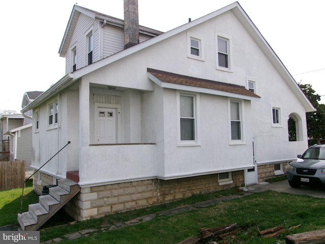 4204 Kenwood Ave, Baltimore, MD 21206 - view of side of property featuring a lawn, stucco siding, fence, and entry steps