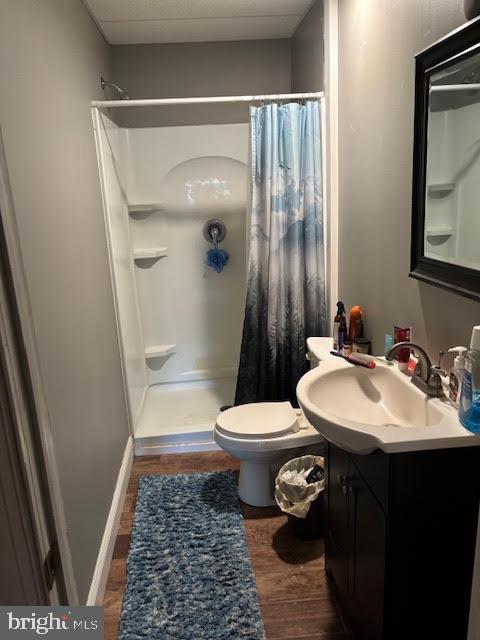 233 Noble St, Kutztown, PA 19530 - bathroom featuring baseboards, toilet, wood finished floors, vanity, and curtained shower