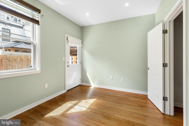 spare room with baseboards, light wood-style floors, and recessed lighting