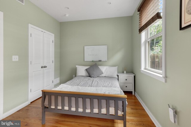 bedroom with baseboards, a closet, and wood finished floors