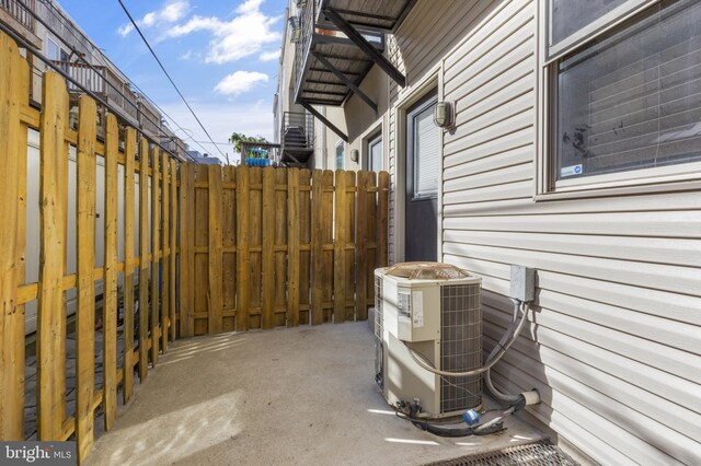 view of patio with cooling unit and fence