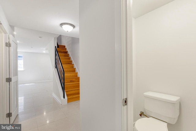 bathroom featuring baseboards, toilet, and tile patterned flooring