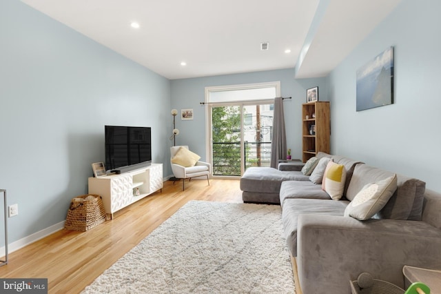 living room with baseboards, visible vents, light wood-style flooring, and recessed lighting