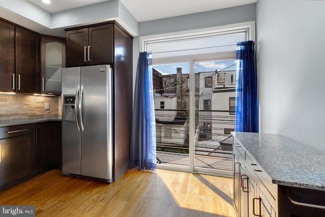 kitchen featuring light wood finished floors, stainless steel fridge with ice dispenser, and dark brown cabinets