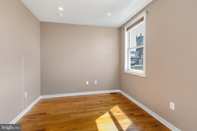 unfurnished room featuring light wood-style flooring, baseboards, and recessed lighting