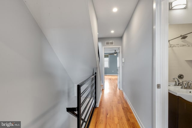 hallway featuring light wood-type flooring, recessed lighting, baseboards, and visible vents