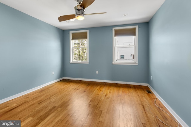unfurnished room with light wood-style floors, baseboards, ceiling fan, and visible vents
