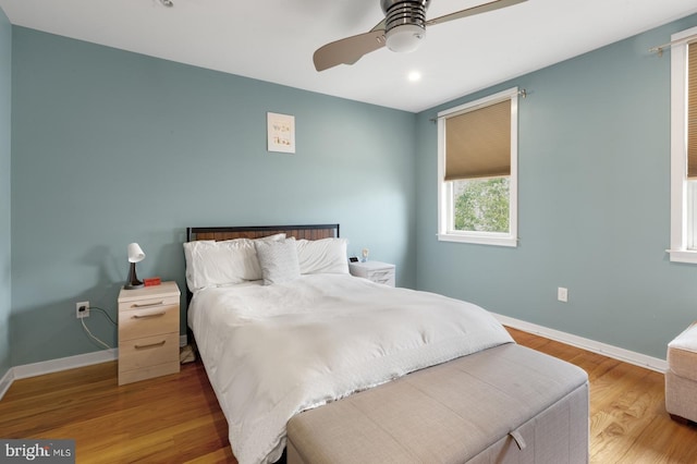 bedroom with baseboards, wood finished floors, and a ceiling fan