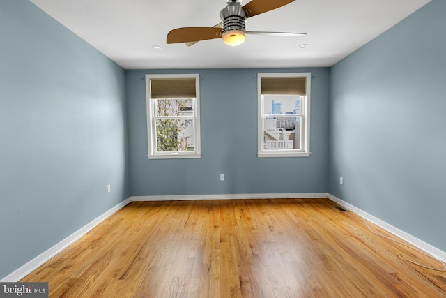 unfurnished room featuring baseboards, light wood-style flooring, and a ceiling fan
