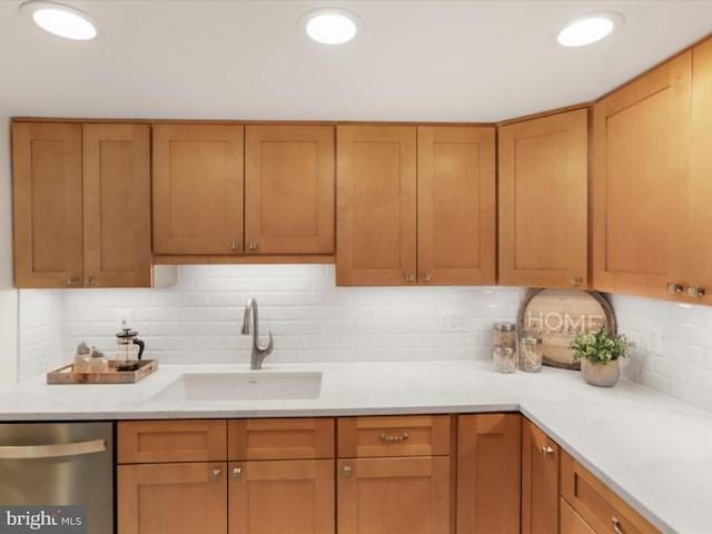 kitchen featuring a sink, light countertops, backsplash, and dishwasher