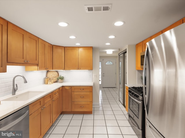 kitchen featuring visible vents, appliances with stainless steel finishes, a sink, light tile patterned floors, and light countertops