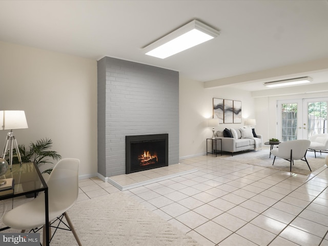 living area with baseboards, a tiled fireplace, and light tile patterned floors