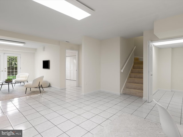 interior space with light tile patterned floors, baseboards, and stairway