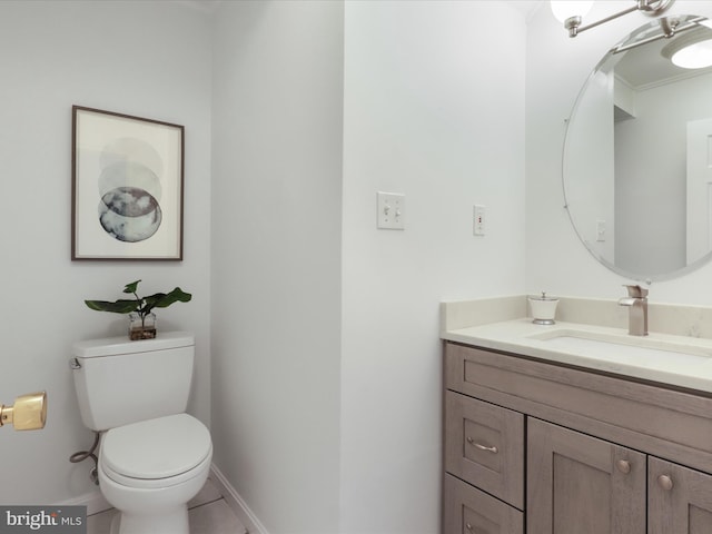 bathroom featuring tile patterned flooring, vanity, toilet, baseboards, and ornamental molding