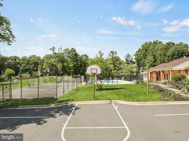 view of sport court featuring fence, a yard, and community basketball court