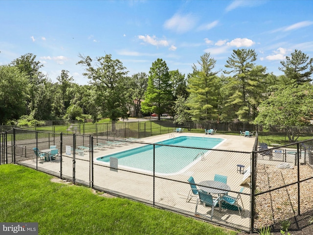 community pool with a lawn and fence