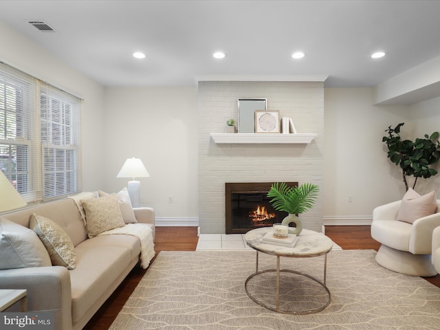 living area featuring baseboards, dark wood-style flooring, and a fireplace