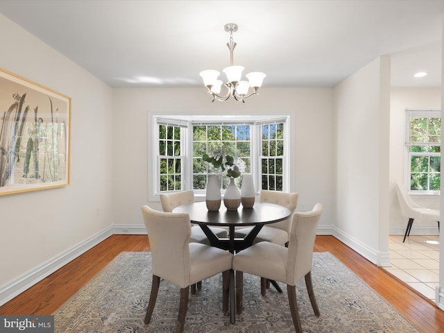 dining area featuring baseboards, wood finished floors, and a notable chandelier