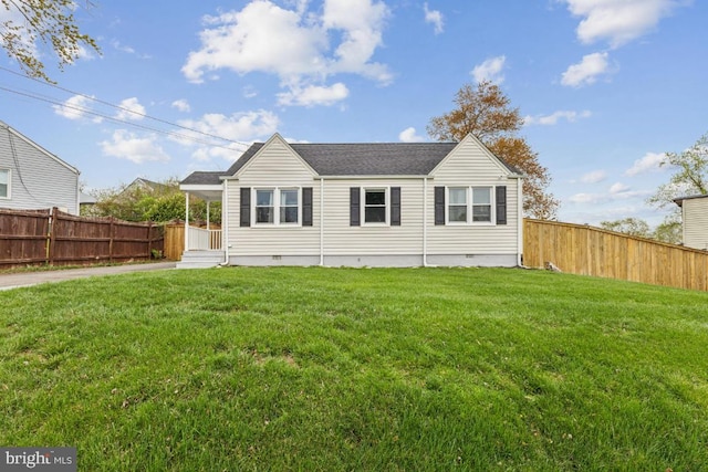 rear view of house with crawl space, a yard, and a fenced backyard
