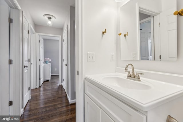 bathroom featuring baseboards, vanity, and wood finished floors