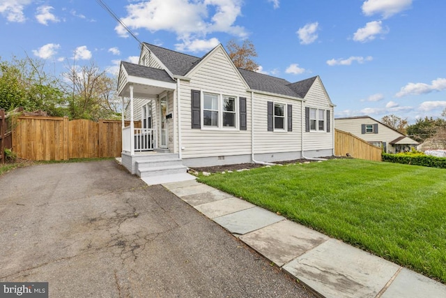 bungalow-style home featuring roof with shingles, crawl space, driveway, a front yard, and fence