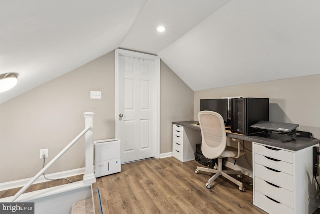 office area with baseboards, wood finished floors, and lofted ceiling