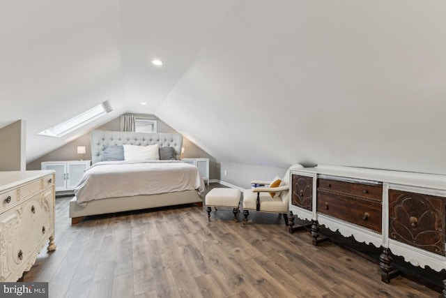 bedroom with lofted ceiling with skylight and wood finished floors