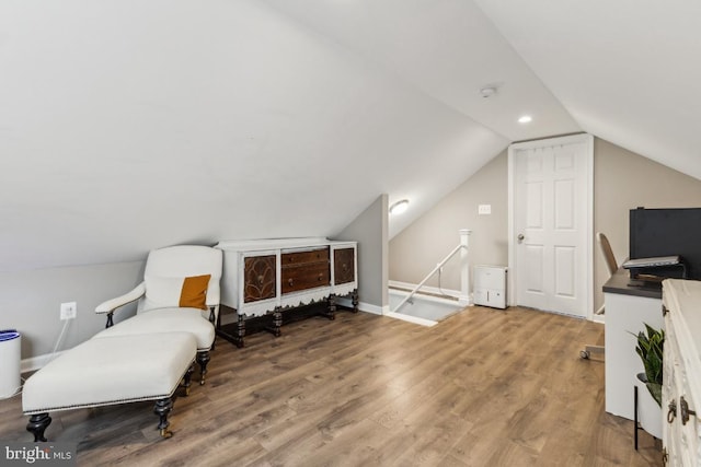 sitting room featuring wood finished floors, baseboards, and vaulted ceiling