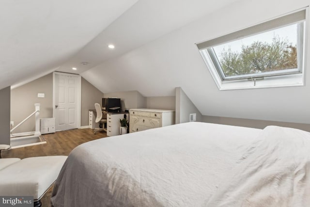 bedroom with vaulted ceiling with skylight, wood finished floors, baseboards, and recessed lighting