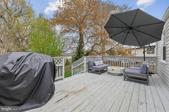 deck with an outdoor fire pit and area for grilling