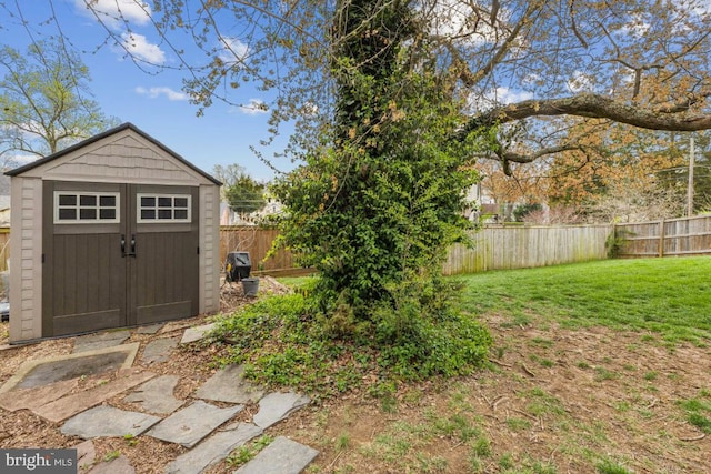 view of yard featuring an outbuilding, a storage unit, and a fenced backyard