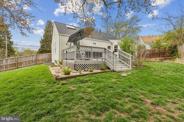 back of property featuring a fenced backyard, a wooden deck, and a lawn