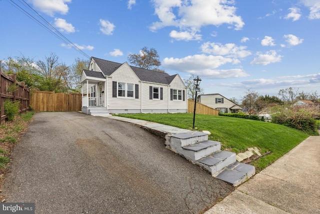 view of front of property featuring aphalt driveway, a front yard, crawl space, and fence