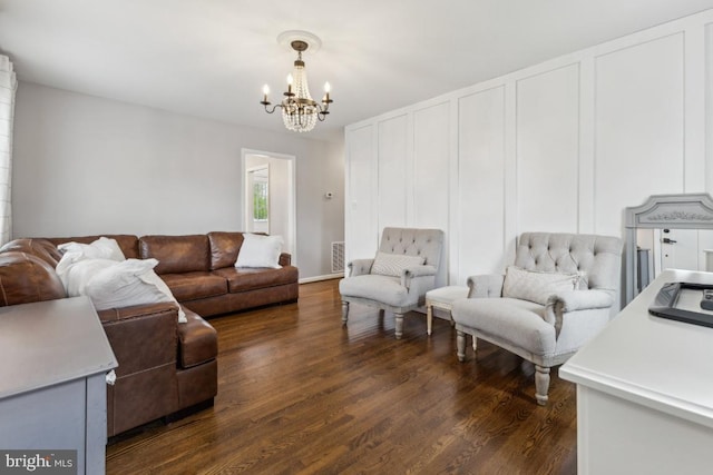 living area featuring dark wood-style flooring, visible vents, and an inviting chandelier