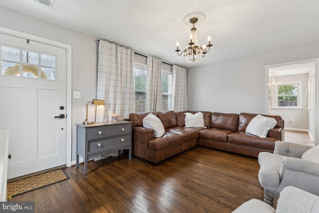 living room with a chandelier, plenty of natural light, and dark wood-type flooring
