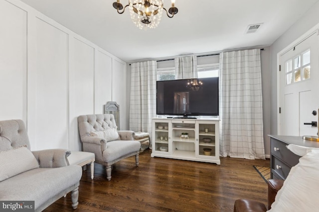 living area with a notable chandelier, dark wood finished floors, and visible vents