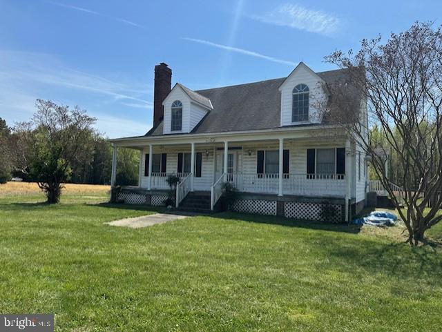 cape cod-style house featuring a chimney, a front lawn, and a porch