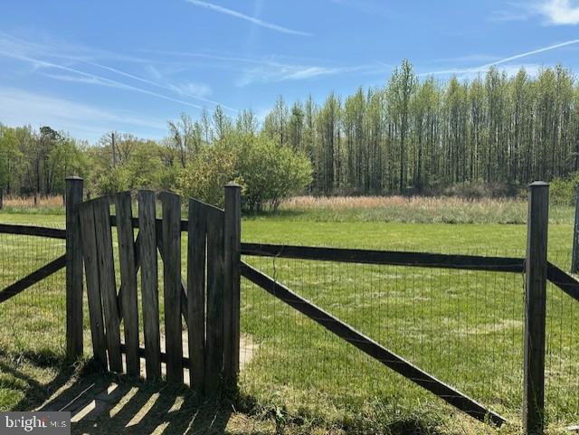 view of gate with fence and a yard