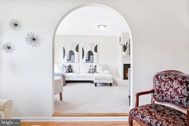 interior space featuring arched walkways, baseboards, and a fireplace