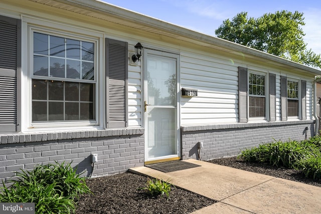 entrance to property featuring brick siding